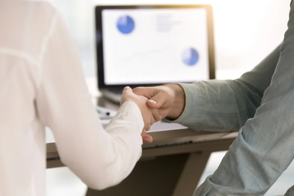 Recruiter and candidate shaking hands after a successful hiring decision