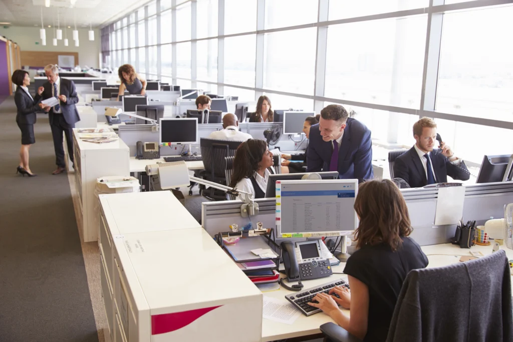 manager discussion with coworker open plan office