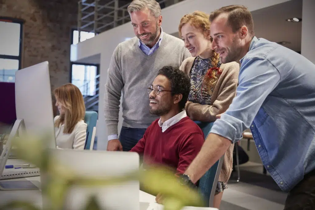 The Tech Debt Trap: How Augmented Teams Are Solving the Mid-Year Talent Crisis Without the Full-Time Overhead 3 Diverse tech team collaborating on a project through it staff augmentation.