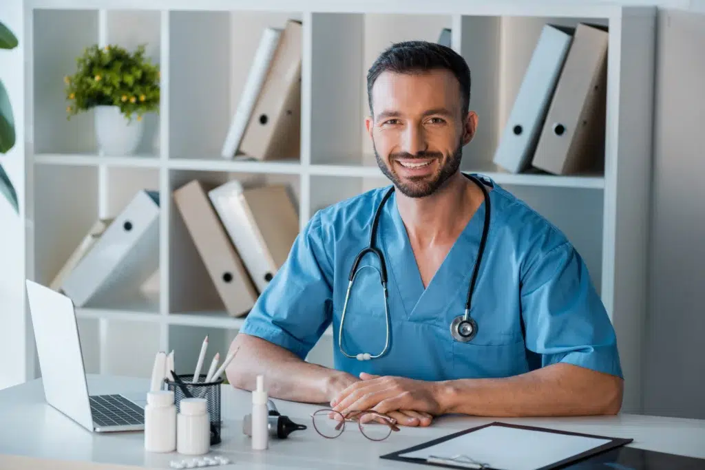 Smiling male medical biller review rules for modifier 25 use.