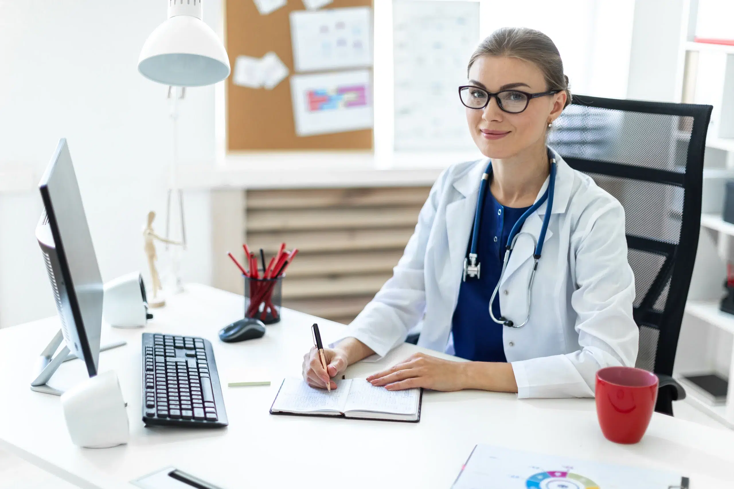 Young doctor at a desk documenting services to support modifier 59.