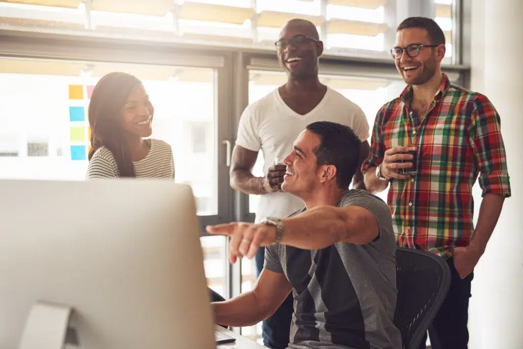 Nearshore team reviewing outsourcing advantages and disadvantages on a computer