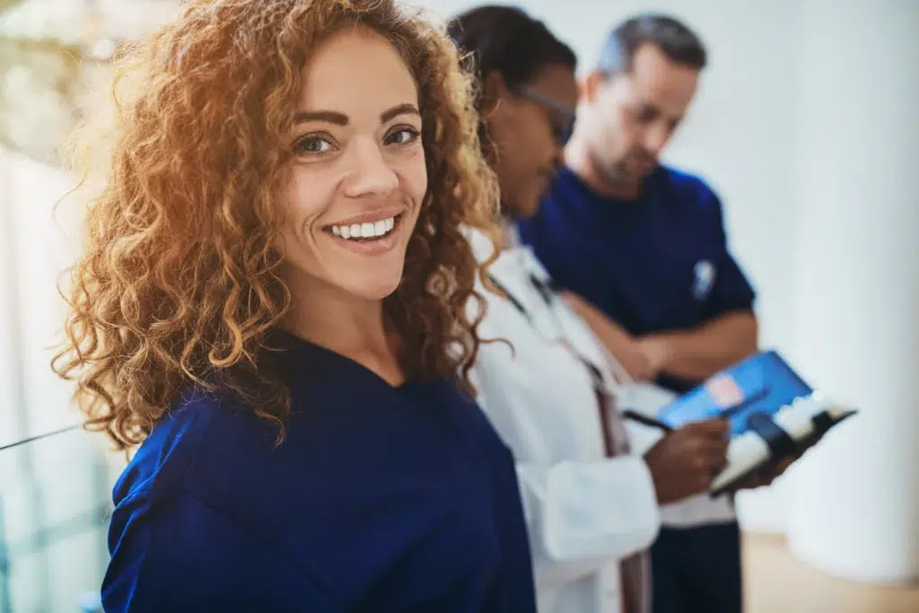 Medical Billing Services for Small Practices: Is It Time to Stop Doing It In-House? 2 Medical intern smiling while discussing medical billing services for small practices.