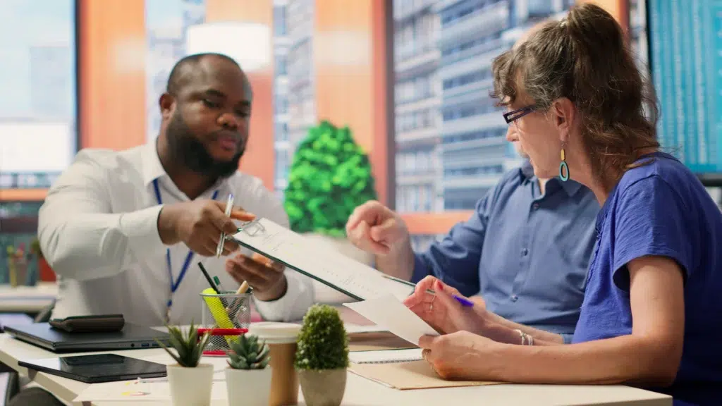 Modern Medical Billing: What is Revenue Cycle Management in 2026 and the Shift Toward Specialized Outsourcing 3 A specialist explaining what is revenue cycle management and financial planning to a client using a clipboard.