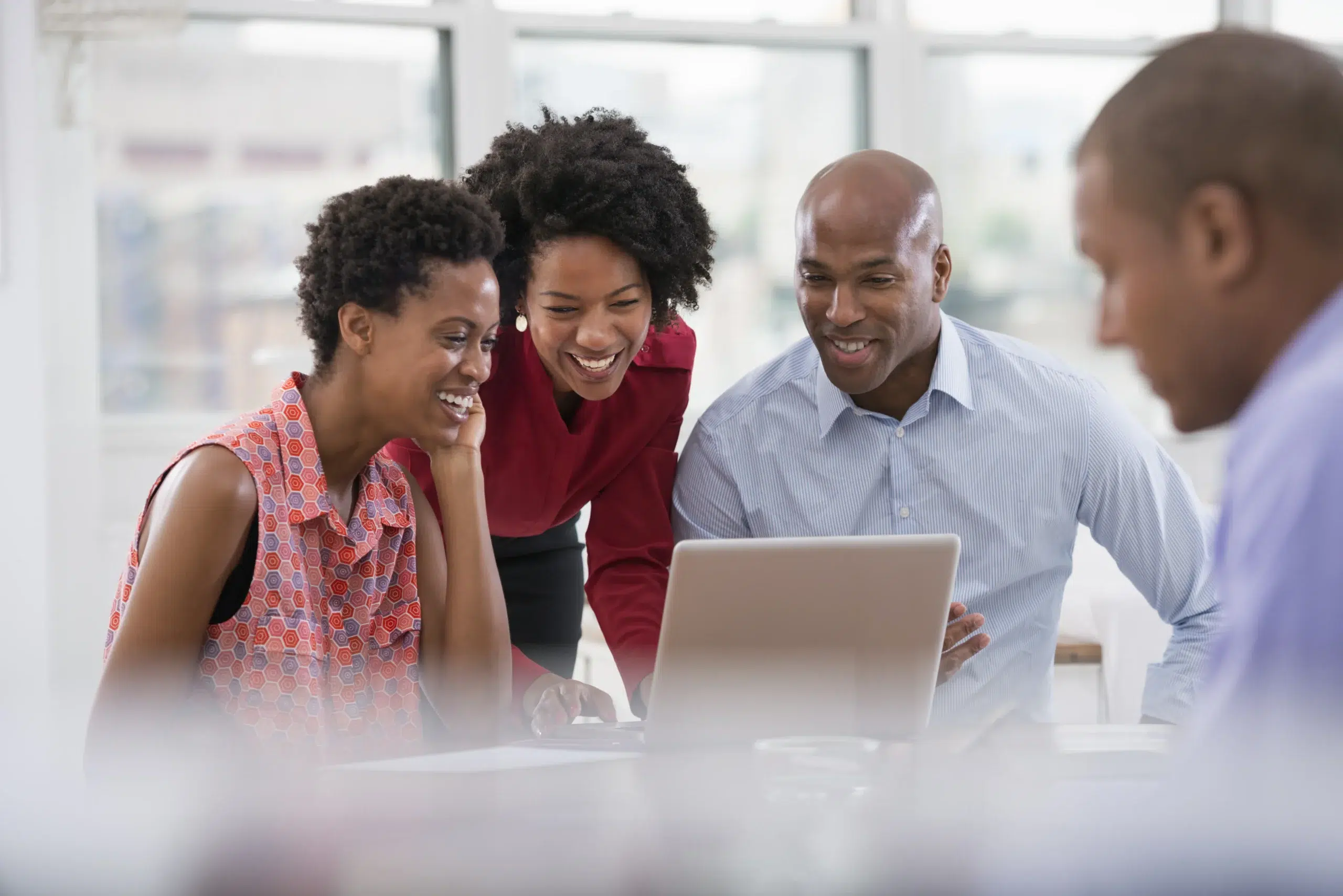 A healthcare leadership team reviewing revenue cycle management healthcare metrics on a laptop during a strategic meeting.
