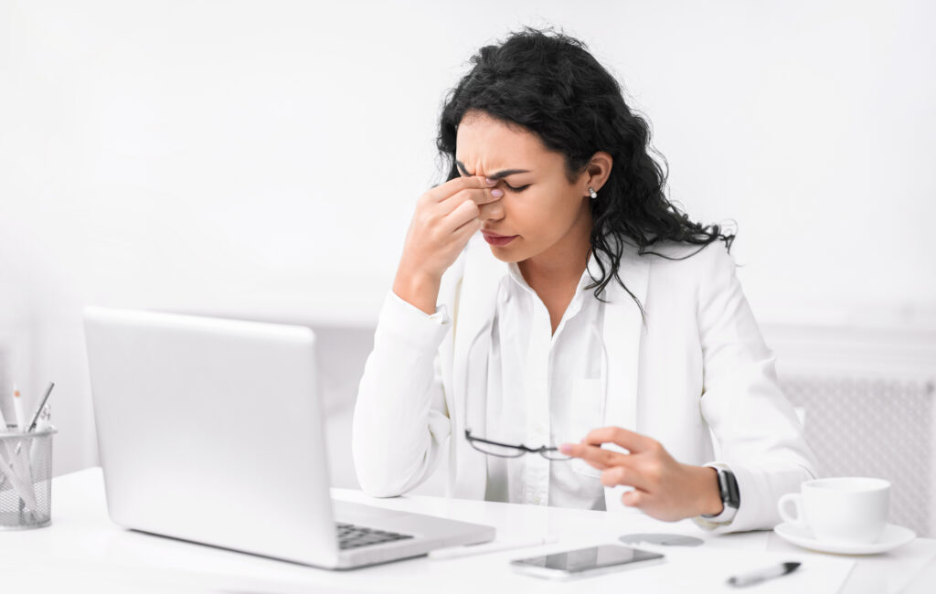 Denial Management in Medical Billing: Why Most Practices Are Losing Revenue They Don't Know About 3 Overworked medical billing specialist struggling with denial management workload at her desk