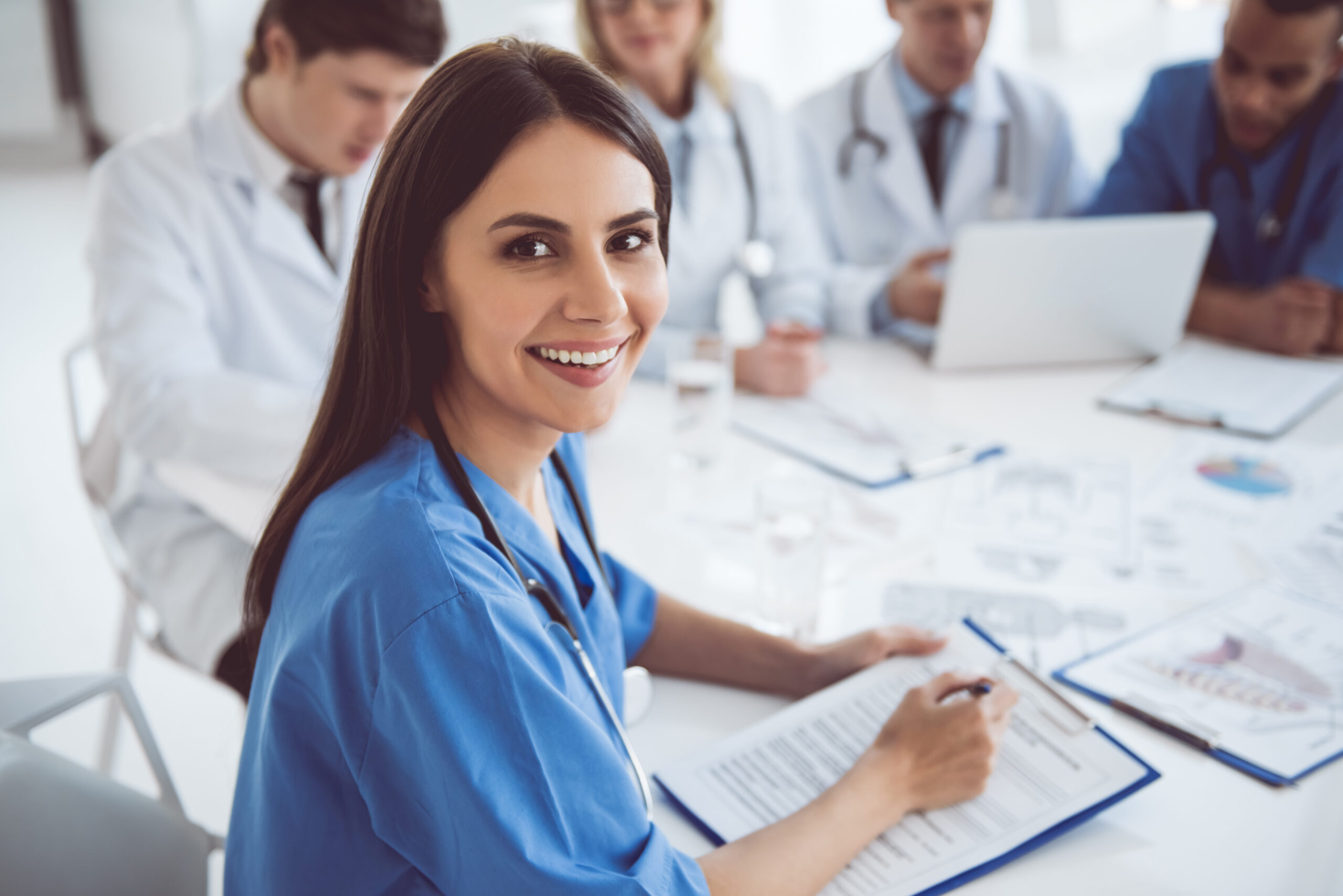Nurse and healthcare team reviewing outsourced billing services data at a meeting