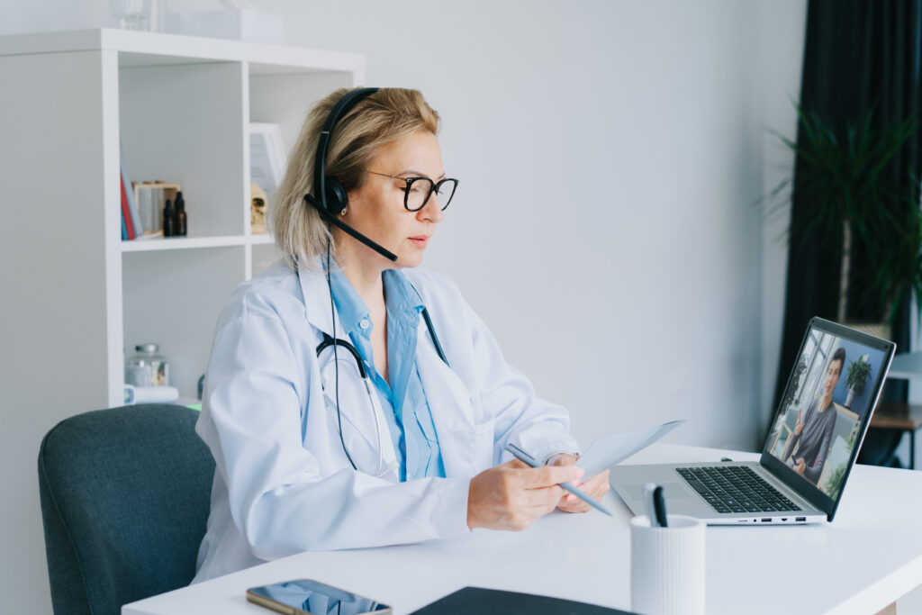 Healthcare intake specialist conducting a remote patient consultation — verifying insurance and demographics before the first clinical encounter