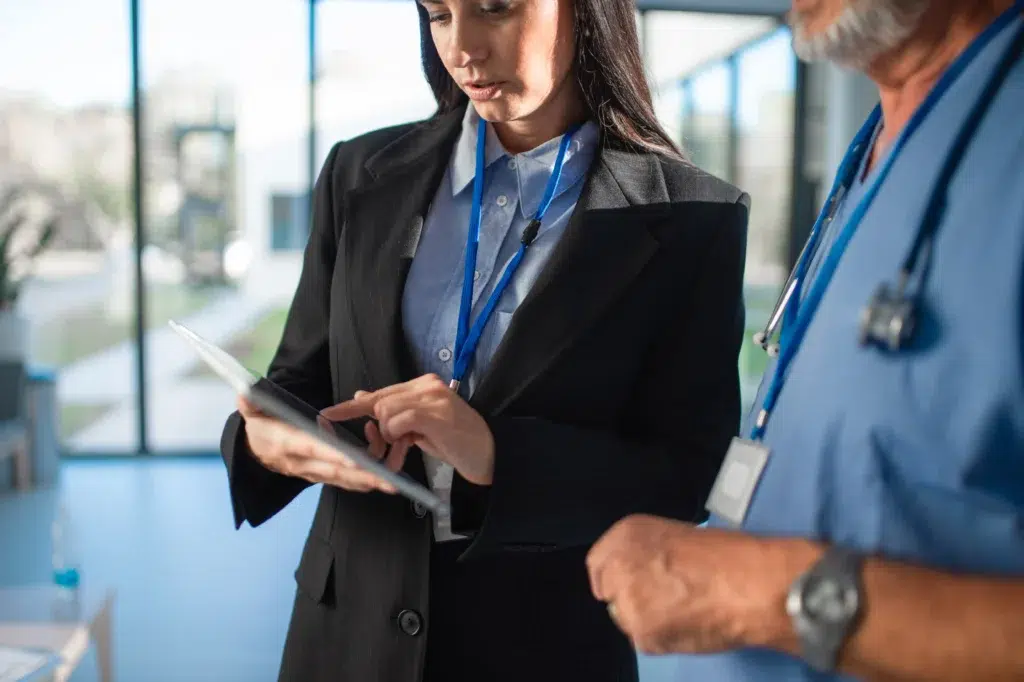 Business consultant and physician reviewing HIPAA compliance checklist requirements before outsource healthcare billing operations
