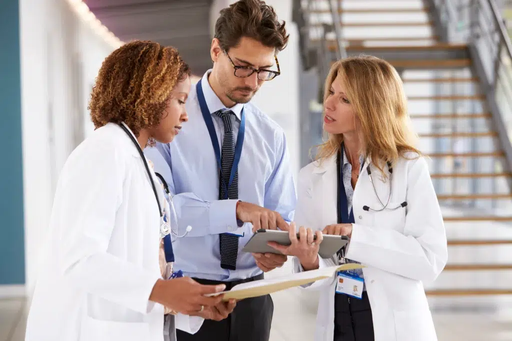 Before You Outsource Healthcare Billing, Ask These Three Compliance Questions 3 Medical professionals reviewing ISO 27001 requirements and compliance standards with their outsourcing BPO partner