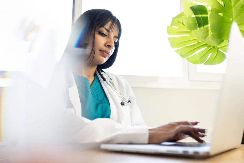 Physician verifying patient insurance coverage on her computer