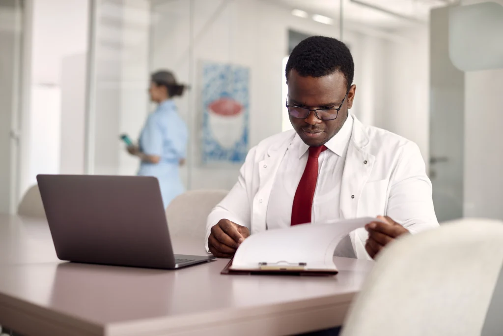 How Much Does It Cost to Outsource Medical Billing? 3 Doctor reviewing reports to understand the cost to outsource medical billing