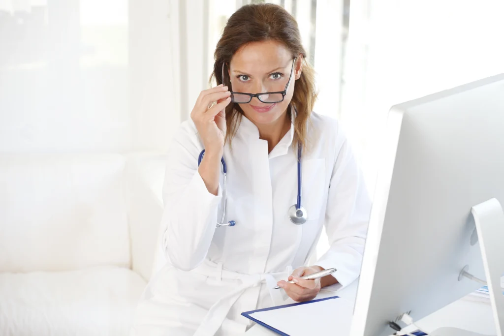 Smiling physician holding a tablet after completing medical credentialing services
