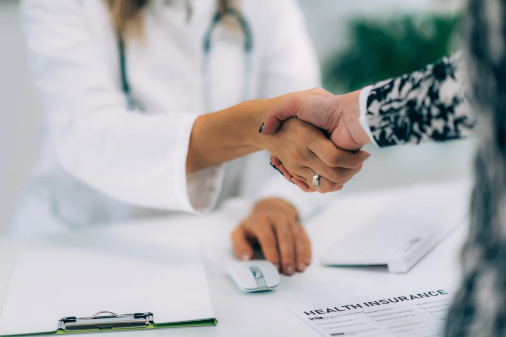 Physician and patient in a clinic supported by prior authorization outsourcing solutions