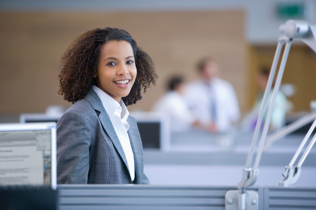 Outsourced Administrative Assistant: What It Costs and How to Hire the Right One 1 Professional smiling in a modern office, representing the support an administrative assistant outsourced provides