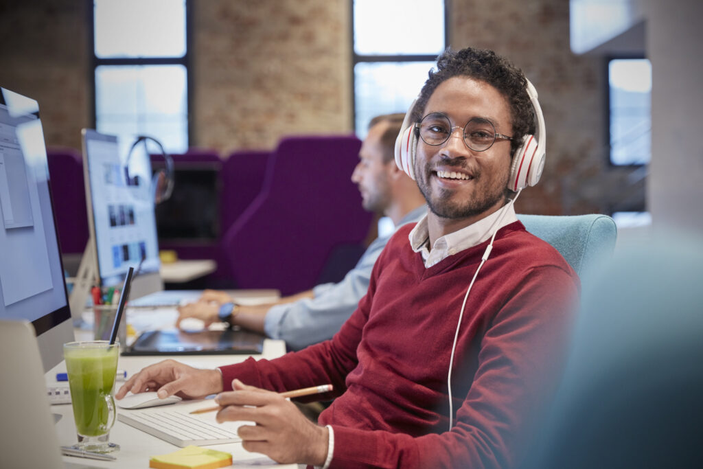 Customer support outsourcing agent answering calls at his office workstation