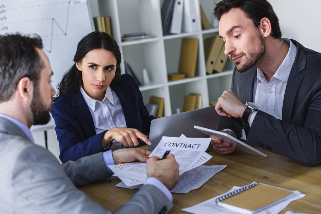 Business meeting reviewing a healthcare denial management services contract before outsourcing