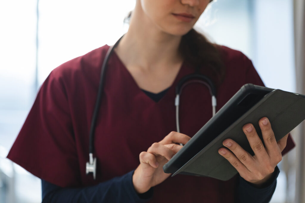 Healthcare staff member checking the schedule on a tablet, a task an outsource medical scheduler can handle